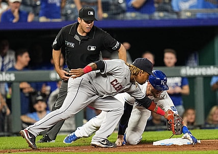Sep 29, 2021; Kansas City, Missouri, USA; Kansas City Royals first baseman Hunter Dozier (17) reaches third base safely as Cleveland Indians third baseman Jose Ramirez (11) applies the tag during the seventh inning at Kauffman Stadium. Mandatory Credit: Jay Biggerstaff-USA TODAY Sports