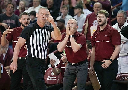 Nov 20, 2022; Charleston, South Carolina, USA; Official Ron Groover (stripes) points to a video board as Charleston Cougars head coach Pat Kelsey reacts in the back ground to a goaltending call in a game against the Virginia Tech Hokies at TD Arena. Mandatory Credit: David Yeazell-USA TODAY Sports