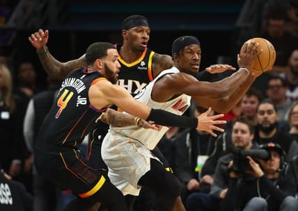Jan 6, 2023; Phoenix, Arizona, USA; Miami Heat forward Jimmy Butler (right) moves the ball against Phoenix Suns guard Duane Washington Jr. (4) and Torrey Craig (0) in the first half at Footprint Center. Mandatory Credit: Mark J. Rebilas-USA TODAY Sports