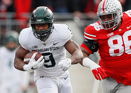 Michigan State running back Kenneth Walker III runs past Ohio State Buckeyes defensive tackle Jerron Cage during the first quarter at Ohio Stadium in Columbus, Ohio on Nov. 20, 2021.

Syndication The Providence Journal