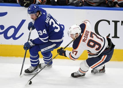 Mar 29, 2021; Toronto, Ontario, CAN; Edmonton Oilers forward Connor McDavid (97) takes the puck away from Toronto Maple Leafs forward Auston Matthews (34) in the first period at Scotiabank Arena. Mandatory Credit: Dan Hamilton-USA TODAY Sports