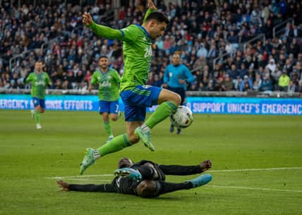 Apr 2, 2022; Saint Paul, Minnesota, USA; Seattle Sounders midfielder Alex Roldan (16) leaps over Minnesota United defender Bakaye Dibassy (12) in the first half at Allianz Field. Mandatory Credit: Matt Blewett-USA TODAY Sports
