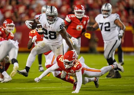 Oct 10, 2022; Kansas City, Missouri, USA; Las Vegas Raiders running back Josh Jacobs (28) runs the ball against Kansas City Chiefs safety Juan Thornhill (22) during the second half at GEHA Field at Arrowhead Stadium. Mandatory Credit: Jay Biggerstaff-USA TODAY Sports