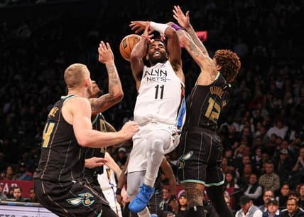 Dec 7, 2022; Brooklyn, New York, USA; Brooklyn Nets guard Kyrie Irving (11) drives to the basket as Charlotte Hornets guard Kelly Oubre Jr. (12) and center Mason Plumlee (24) defend during the second half at Barclays Center. Mandatory Credit: Vincent Carchietta-USA TODAY Sports