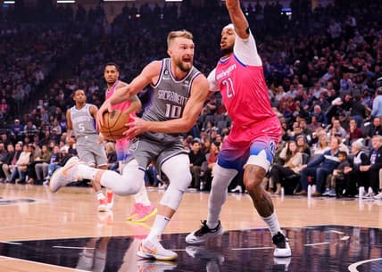 Dec 23, 2022; Sacramento, California, USA; Sacramento Kings power forward Domantas Sabonis (10) drives in against Washington Wizards center Daniel Gafford (21) during the first quarter at Golden 1 Center. Mandatory Credit: Kelley L Cox-USA TODAY Sports