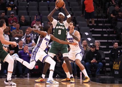 Mar 16, 2022; Sacramento, California, USA; Milwaukee Bucks forward Bobby Portis Jr. (9) controls the ball between Sacramento Kings guard Justin Holiday (9) and forward Trey Lyles (41) during the first quarter at Golden 1 Center. Mandatory Credit: Kelley L Cox-USA TODAY Sports