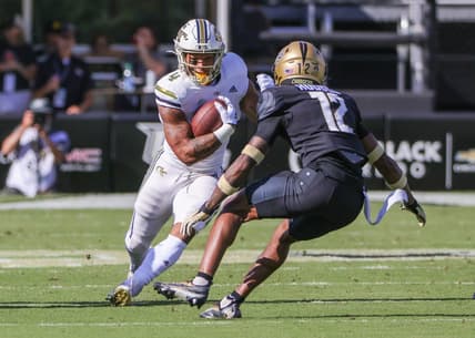 Sep 24, 2022; Orlando, Florida, USA; Georgia Tech Yellow Jackets running back Dontae Smith (4) runs the ball against UCF Knights defensive back Justin Hodges (12) during the first quarter at FBC Mortgage Stadium. Mandatory Credit: Mike Watters-USA TODAY Sports