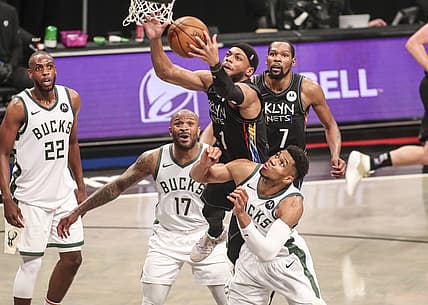 Jun 7, 2021; Brooklyn, New York, USA; Brooklyn Nets guard Bruce Brown (1) jumps over Milwaukee Bucks forwards P.J. Tucker (17) and Giannis Antetokounmpo (34) to grab a rebound in the third quarter during game two in the second round of the 2021 NBA Playoffs. at Barclays Center. Mandatory Credit: Wendell Cruz-USA TODAY Sports