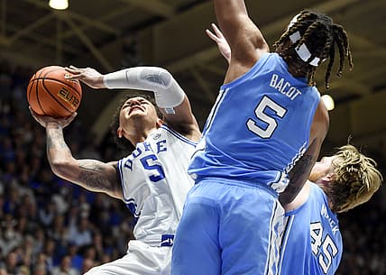 Mar 5, 2022; Durham, North Carolina, USA; Duke Blue Devils forward Paolo Banchero (5) attempts to shoot over North Carolina Tar Heels forward Brady Manek (45) and forward Armando Bacot (5) during the second half  at Cameron Indoor Stadium.  The Tar Heels won 94-81. Mandatory Credit: Rob Kinnan-USA TODAY Sports