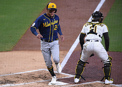 Apr 20, 2021; San Diego, California, USA; Milwaukee Brewers right fielder Avisail Garcia (L) scores a run on a two-RBI single by catcher Omar Narvaez (not pictured) during the third inning as San Diego Padres catcher Luis Campusano (21) looks on at Petco Park. Mandatory Credit: Orlando Ramirez-USA TODAY Sports