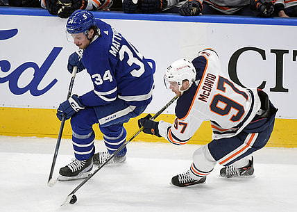 Mar 29, 2021; Toronto, Ontario, CAN; Edmonton Oilers forward Connor McDavid (97) takes the puck away from Toronto Maple Leafs forward Auston Matthews (34) in the first period at Scotiabank Arena. Mandatory Credit: Dan Hamilton-USA TODAY Sports