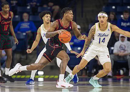 Dec 28, 2022; Tulsa, Oklahoma, USA;  Houston Cougars guard Marcus Sasser (0) dribbles past Tulsa Golden Hurricane guard Anthony Pritchard (14) during the first half at Reynolds Center. Mandatory Credit: Brett Rojo-USA TODAY Sports