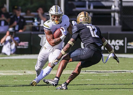 Sep 24, 2022; Orlando, Florida, USA; Georgia Tech Yellow Jackets running back Dontae Smith (4) runs the ball against UCF Knights defensive back Justin Hodges (12) during the first quarter at FBC Mortgage Stadium. Mandatory Credit: Mike Watters-USA TODAY Sports