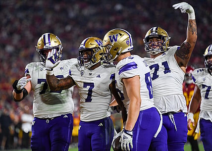Nov 4, 2023; Los Angeles, California, USA; Washington Huskies running back Dillon Johnson (7), Washington Huskies offensive lineman Nate Kalepo (71) and other teammates celebrate against the USC Trojans during the second quarter at United Airlines Field at Los Angeles Memorial Coliseum. Mandatory Credit: Jonathan Hui-USA TODAY Sports