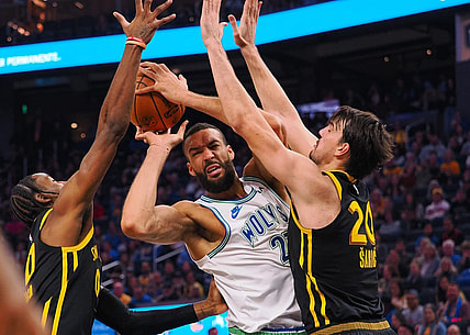 Nov 12, 2023; San Francisco, California, USA; Minnesota Timberwolves center Rudy Gobert (27) controls th ball against Golden State Warriors forward Jonathan Kuminga (00) and forward Dario Saric (20) during the second quarter at Chase Center. Mandatory Credit: Kelley L Cox-USA TODAY Sports