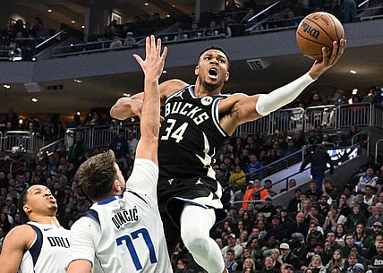 Nov 18, 2023; Milwaukee, Wisconsin, USA; Milwaukee Bucks forward Giannis Antetokounmpo (34) drives to the basket against Dallas Mavericks guard Luka Doncic (77) in the first half at Fiserv Forum. Mandatory Credit: Michael McLoone-USA TODAY Sports