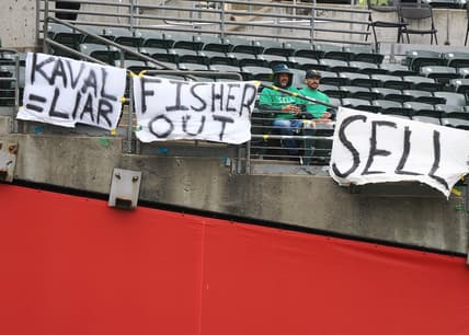 May 28, 2023; Oakland, California, USA; Oakland Athletics fans sit between signs reading  Kaval=liar ,  Fisher out  and  sell  during the first inning against the Houston Astros at Oakland-Alameda County Coliseum. Mandatory Credit: Kelley L Cox-USA TODAY Sports