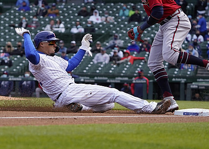 Apr 16, 2021; Chicago, Illinois, USA; Chicago Cubs shortstop Javier Baez slides safely into third base against the Atlanta Braves during the second inning at Wrigley Field. All players on both teams are wearing number 42 in honor of Jackie Robinson Day. Mandatory Credit: David Banks-USA TODAY Sports
