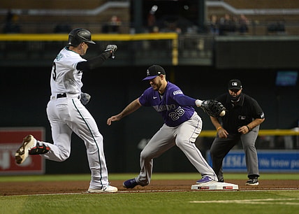 Apr 30, 2021; Phoenix, Arizona, USA; Arizona Diamondbacks shortstop Nick Ahmed (13) reaches first base safely as Colorado Rockies first baseman C.J. Cron (25) misplays a throw during the second inning at Chase Field. Mandatory Credit: Joe Camporeale-USA TODAY Sports