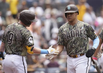 Jun 18, 2023; San Diego, California, USA;  San Diego Padres left fielder Juan Soto (right) is congratulated by first baseman Jake Cronenworth (9) after scoring against the Tampa Bay Rays during the third inning at Petco Park. Mandatory Credit: Ray Acevedo-USA TODAY Sports
