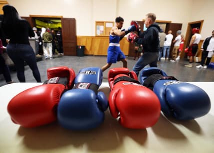 Michael Cappiello owner of Cappiello Boxing Gym with his boxer Will Longwe, 27, who hits the hand pads against Mchilandy Noel of Bishop's Gym in West Bridgewater during the Southern New England Golden Gloves opening night at the Fall River PAL Hall on Saturday, Jan. 20, 2024.