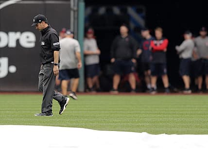 Aug 21, 2022; Cleveland, Ohio, USA; Umpire David Rackley inspects left field after a heavy rain prior to the start of the Cleveland Guardians and Chicago White Sox game at Progressive Field. Mandatory Credit: Aaron Josefczyk-USA TODAY Sports