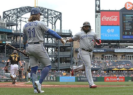 Sep 4, 2022; Pittsburgh, Pennsylvania, USA;  Toronto Blue Jays shortstop Bo Bichette (11) congratulates first baseman Vladimir Guerrero Jr. (right) after Guerrero scored a run against the Pittsburgh Pirates during the third inning at PNC Park. Mandatory Credit: Charles LeClaire-USA TODAY Sports