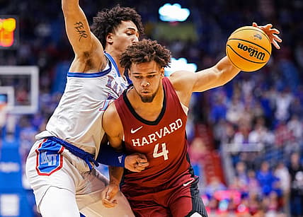 Dec 22, 2022; Lawrence, Kansas, USA; Harvard Crimson forward Chris Ledlum (4) drives against Kansas Jayhawks forward Jalen Wilson (10) during the first half at Allen Fieldhouse. Mandatory Credit: Jay Biggerstaff-USA TODAY Sports