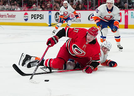 Dec 23, 2023; Raleigh, North Carolina, USA; Carolina Hurricanes right wing Andrei Svechnikov (37) is knocked off the puck during the first period at PNC Arena. Mandatory Credit: James Guillory-USA TODAY Sports