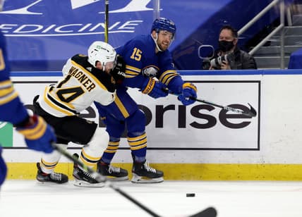 Apr 23, 2021; Buffalo, New York, USA;  Buffalo Sabres center Riley Sheahan (15) makes a pass as Boston Bruins right wing Chris Wagner (14) defends during the first period at KeyBank Center. Mandatory Credit: Timothy T. Ludwig-USA TODAY Sports