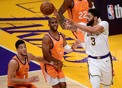 May 30, 2021; Los Angeles, California, USA; Los Angeles Lakers forward Anthony Davis (3) passes the ball against Phoenix Suns guard Chris Paul (3) and guard Devin Booker (1) during the first half in game four of the first round of the 2021 NBA Playoffs. at Staples Center. Mandatory Credit: Gary A. Vasquez-USA TODAY Sports