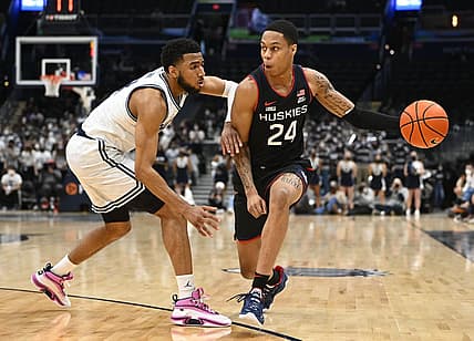 Feb 27, 2022; Washington, District of Columbia, USA; Connecticut Huskies guard Jordan Hawkins (24) dribbles past Georgetown Hoyas guard Donald Carey (13) during the first half at Capital One Arena. Mandatory Credit: Brad Mills-USA TODAY Sports
