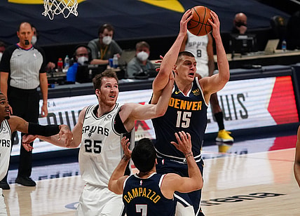 Apr 9, 2021; Denver, Colorado, USA; Denver Nuggets center Nikola Jokic (15) pulls a rebound away from San Antonio Spurs center Jakob Poeltl (25) in the third quarter at Ball Arena. Mandatory Credit: Ron Chenoy-USA TODAY Sports