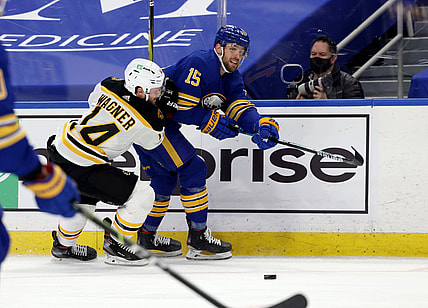 Apr 23, 2021; Buffalo, New York, USA;  Buffalo Sabres center Riley Sheahan (15) makes a pass as Boston Bruins right wing Chris Wagner (14) defends during the first period at KeyBank Center. Mandatory Credit: Timothy T. Ludwig-USA TODAY Sports