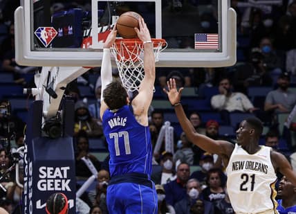 Feb 17, 2022; New Orleans, Louisiana, USA; Dallas Mavericks guard Luka Doncic (77) dunks the ball against New Orleans Pelicans forward Tony Snell (21) during the second half at the Smoothie King Center. Mandatory Credit: Stephen Lew-USA TODAY Sports