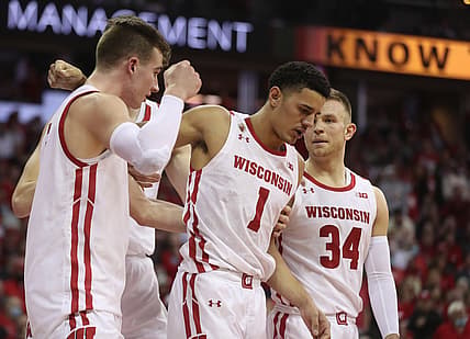 Mar 6, 2022; Madison, Wisconsin, USA; An injured Wisconsin Badgers guard Johnny Davis (1) is helped off the court by Wisconsin Badgers forward Tyler Wahl  (left) and Brad Davison (34) at the Kohl Center. Mandatory Credit: Mary Langenfeld-USA TODAY Sports