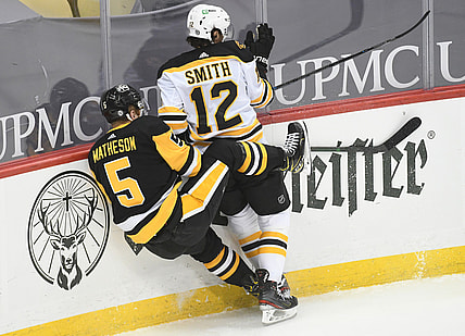 Apr 27, 2021; Pittsburgh, Pennsylvania, USA;  Boston Bruins center Craig Smith (12) and Pittsburgh Penguins defenseman  Mike Matheson (5) crash into each other during the first period at PPG Paints Arena. Mandatory Credit: Philip G. Pavely-USA TODAY Sports