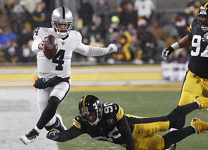 Dec 24, 2022; Pittsburgh, Pennsylvania, USA;  Las Vegas Raiders quarterback Derek Carr (4) runs the ball as Pittsburgh Steelers linebacker T.J. Watt (90) defends during the first quarter at Acrisure Stadium. Mandatory Credit: Charles LeClaire-USA TODAY Sports