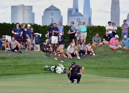 Aug 19, 2021; Jersey City, New Jersey, USA; Jon Rahm studies his putt on the 18th hole during the first round of The Northern Trust golf tournament at the Liberty National Golf Club. Mandatory Credit: Mark Konezny-USA TODAY Sports