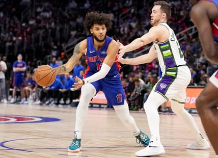 Apr 8, 2022; Detroit, Michigan, USA; Detroit Pistons forward Isaiah Livers (12) gets defended by Milwaukee Bucks guard Pat Connaughton (24) during the second quarter at Little Caesars Arena. Mandatory Credit: Raj Mehta-USA TODAY Sports
