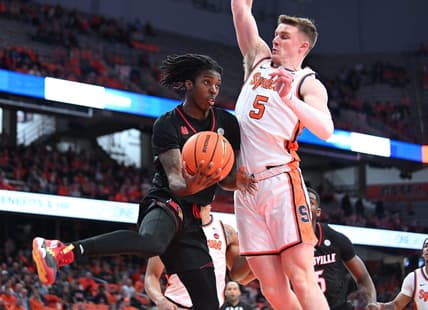 Feb 7, 2024; Syracuse, New York, USA; Louisville Cardinals guard Ty-Laur Johnson (4) passes the ball under the basket with Syracuse Orange guard Justin Taylor (5) defending in the first half at the JMA Wireless Dome. Mandatory Credit: Mark Konezny-USA TODAY Sports