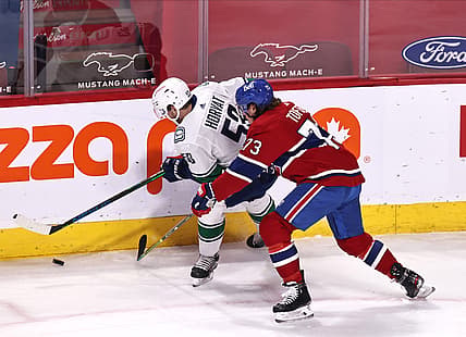 Mar 19, 2021; Montreal, Quebec, CAN; Vancouver Canucks center Bo Horvat (53) and Montreal Canadiens right wing Tyler Toffoli (73) battle for the puck during the first period at Bell Centre. Mandatory Credit: Jean-Yves Ahern-USA TODAY Sports
