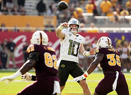 Nov 18, 2023; Tempe, Arizona, USA; Oregon Ducks quarterback Bo Nix (10) throws a touchdown pass with pressure from Arizona State Sun Devils defensive lineman B.J. Green II (35) in the first half at Mountain America Stadium. Mandatory Credit: Rob Schumacher-Arizona Republic