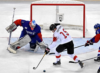Feb 17, 2018; Gangneung, South Korea; Korea goaltender Matt Dalton (1) defends the net against Switzerland forward Gregory Hofmann (15) during men's ice hockey Group A play in the Pyeongchang 2018 Olympic Winter Games at Gangneung Hockey Centre. Mandatory Credit: David E. Klutho-USA TODAY Sports