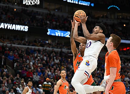 Mar 27, 2022; Chicago, IL, USA; Kansas Jayhawks guard Ochai Agbaji (30) shoots past Miami Hurricanes guard Kameron McGusty (23) during the first half in the finals of the Midwest regional of the men's college basketball NCAA Tournament at United Center. Mandatory Credit: Jamie Sabau-USA TODAY Sports
