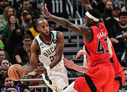 Mar 19, 2023; Milwaukee, Wisconsin, USA; Milwaukee Bucks forward Khris Middleton (22) looks to pass against Toronto Raptors forward Pascal Siakam (43) in the fourth quarter at Fiserv Forum. Mandatory Credit: Benny Sieu-USA TODAY Sports