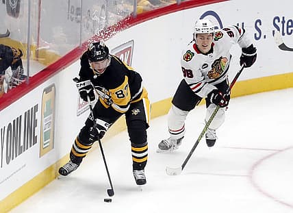 Oct 10, 2023; Pittsburgh, Pennsylvania, USA; Pittsburgh Penguins center Sidney Crosby (87) moves the puck ahead of Chicago Blackhawks center Connor Bedard (98) during the second period at the PPG Paints Arena. Chicago won 4-2. Mandatory Credit: Charles LeClaire-USA TODAY Sports