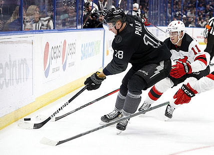 Nov 20, 2021; Tampa, Florida, USA; Tampa Bay Lightning left wing Ondrej Palat (18) passes the puck as New Jersey Devils left wing Andreas Johnsson (11) defends during the second period at Amalie Arena. Mandatory Credit: Kim Klement-USA TODAY Sports