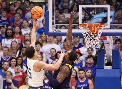 Feb 25, 2023; Lawrence, Kansas, USA; Kansas Jayhawks guard Kevin McCullar Jr. (15) shoots as West Virginia Mountaineers forward Jimmy Bell Jr. (15) defends during the first half at Allen Fieldhouse. Mandatory Credit: Denny Medley-USA TODAY Sports