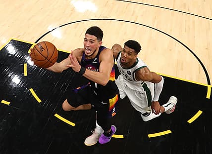 Jul 17, 2021; Phoenix, Arizona, USA; Phoenix Suns guard Devin Booker (1) drives to the basket against Milwaukee Bucks forward Giannis Antetokounmpo (34) during game five of the 2021 NBA Finals at Phoenix Suns Arena. Mandatory Credit: Mark J. Rebilas-USA TODAY Sports
